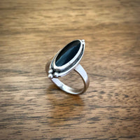 Vintage Boho Style Black Onyx Silver Ring standing on Wooden Desk