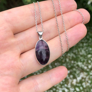 Vintage Blue John Oval Silver Pendant in the hand outdoors