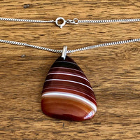 Vintage 925 Silver Polished Red Banded Agate Pendant and Chain with Wooden Background