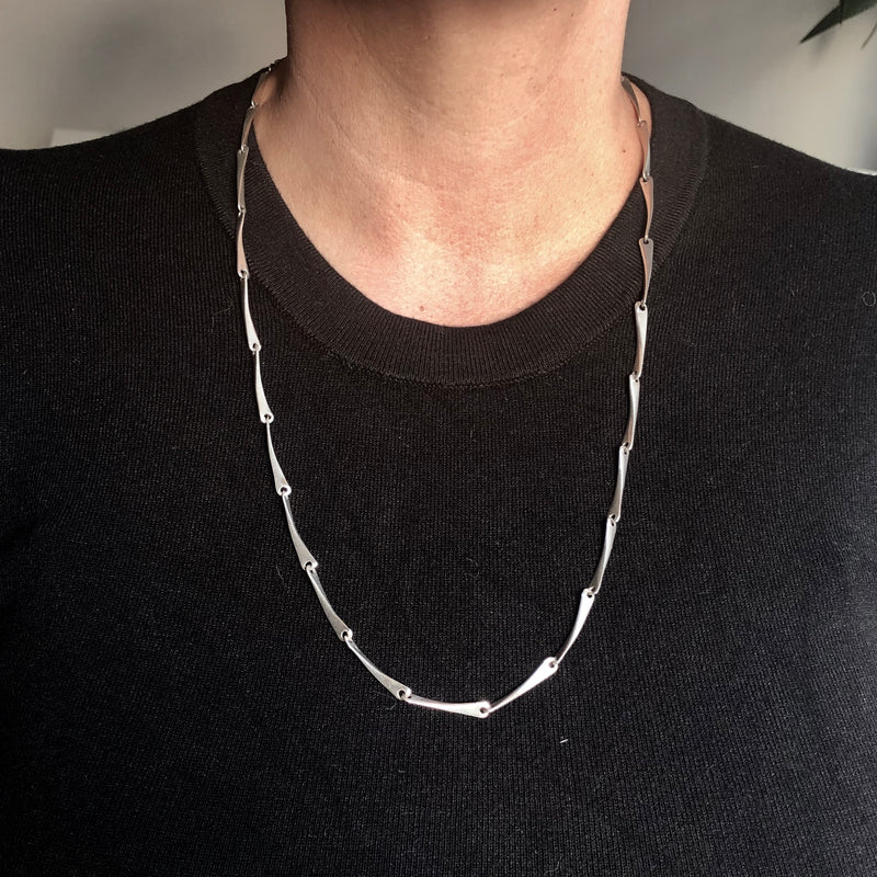A Modernist Hammered Sterling Silver Linked Necklace worn withBlack