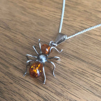 Vintage Silver and Amber Spider Pendant and Chain lying Flat on Wooden Table
