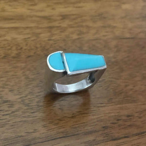 Vintage Modernist Turquoise Inlay Silver Statement Ring Standing on Wooden Desk