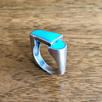 Vintage Modernist Turquoise Inlay Silver Statement Ring standing on Wooden Table