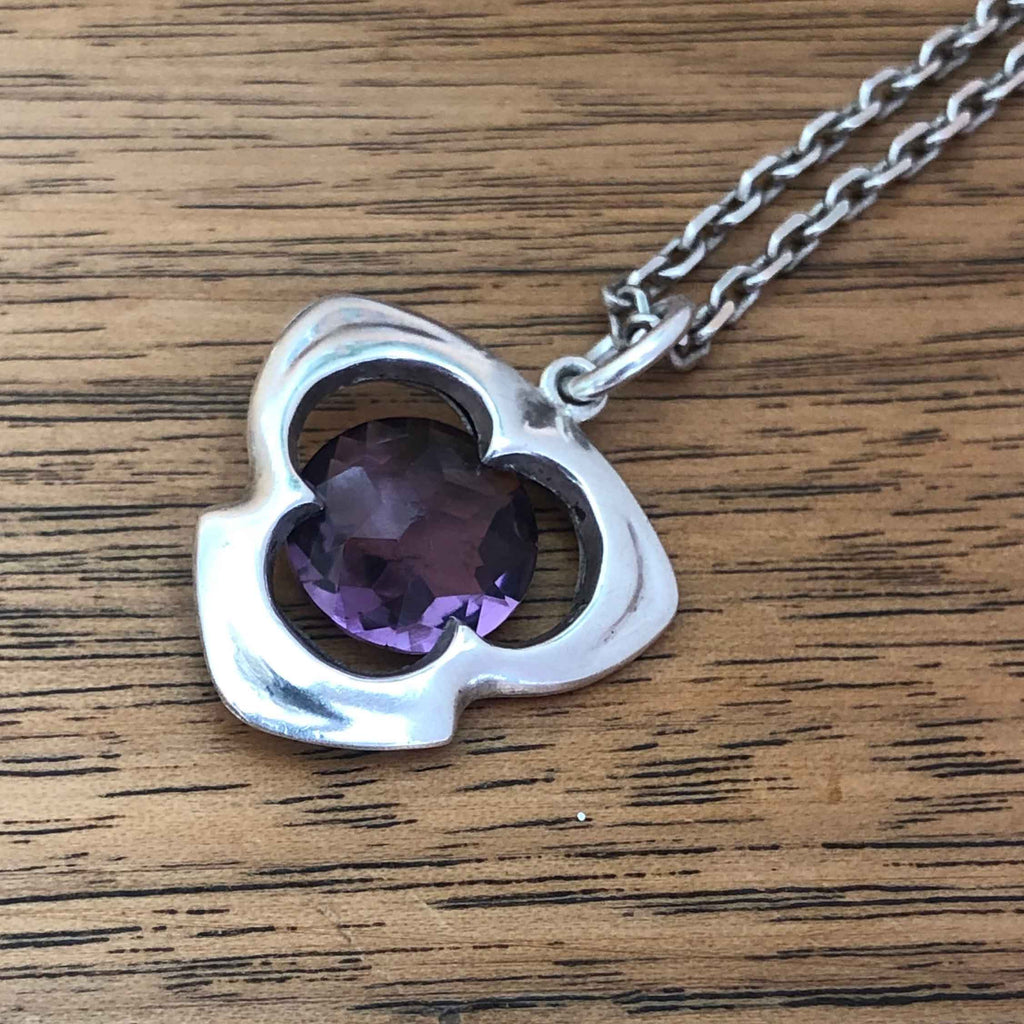 Antique Sterling Silver & Amethyst Pendant by Pendleton and Sons 1908 lying on Wooden Table