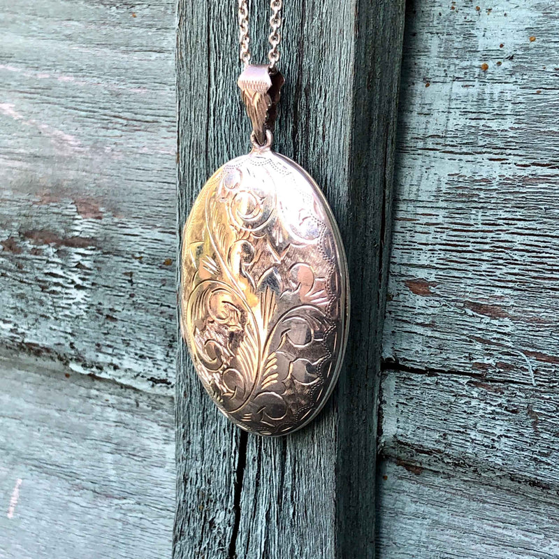 Large Vintage Engraved Silver Oval Locket - With a 22” Long Silver Chain hanging on painted wood back ground
