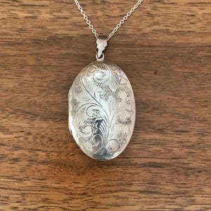 Large Vintage Engraved Silver Oval Locket - With a 22” Long Silver Chain on Wood Background