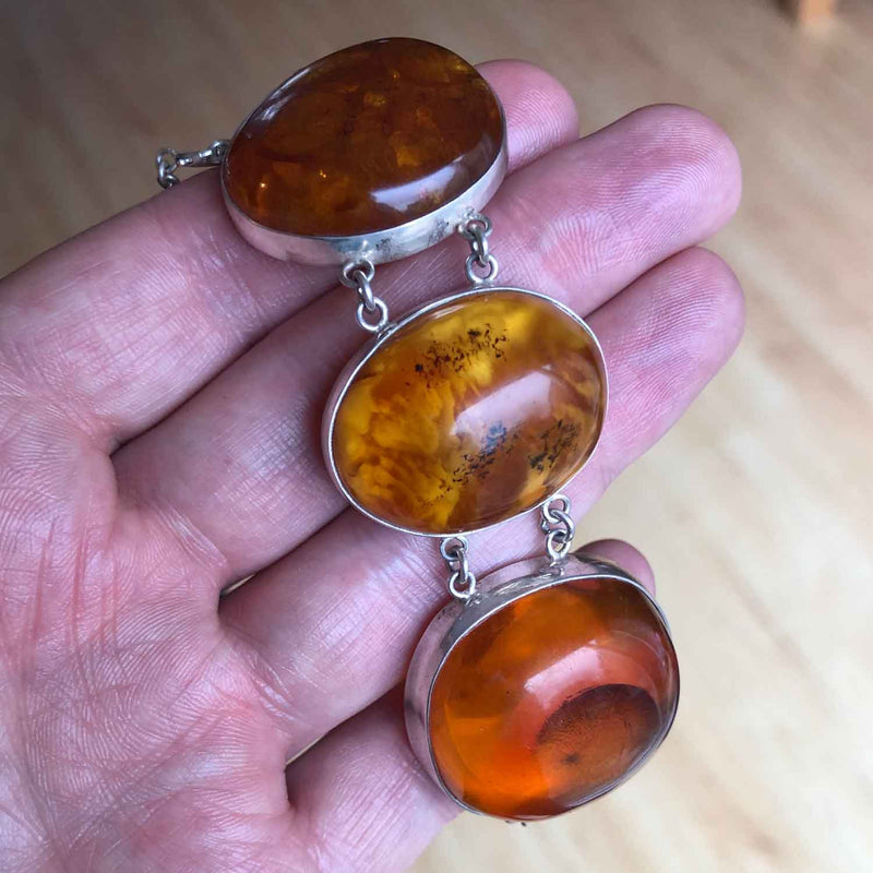 Chunky Vintage Sterling Silver Baltic Amber Bracelet draped over a hand